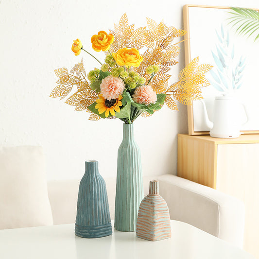 Decorative vases with a bouquet of flowers on a white surface.