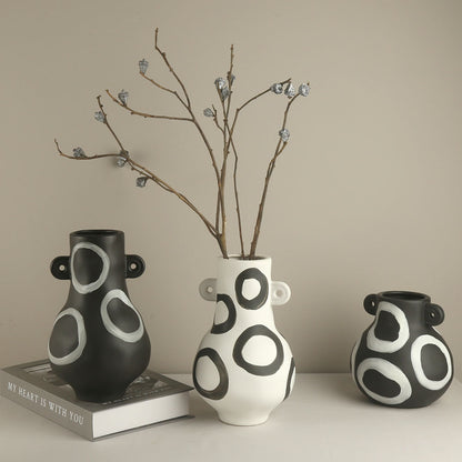 Three ceramic vases with circular patterns on a neutral background