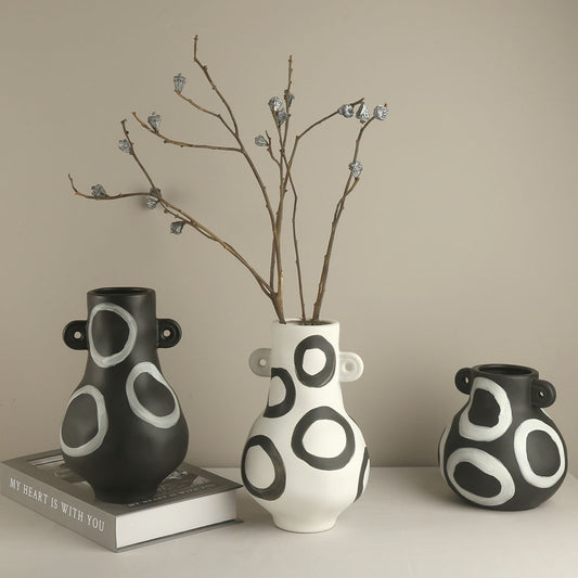 Three ceramic vases with circular patterns on a neutral background