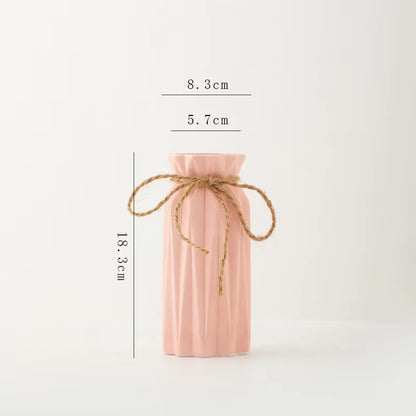 Pink ribbed vase with twine on a white background with measurements.