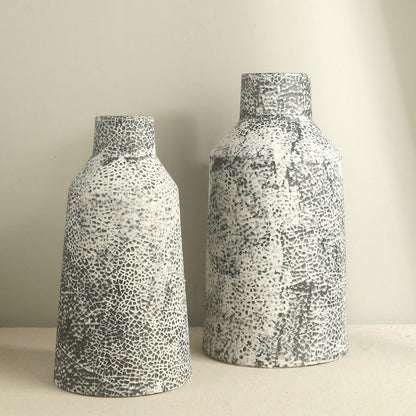Two ceramic vases with a textured pattern on a neutral background