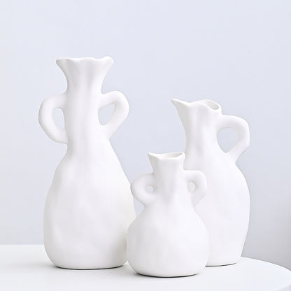 Three white ceramic vases of different shapes on a light gray background