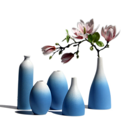 Set of five gradient blue vases with a branch of flowers on a white background