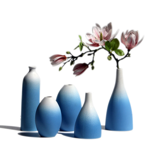 Set of five gradient blue vases with a branch of flowers on a white background