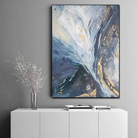 Abstract art piece on a gray wall above a white cabinet.