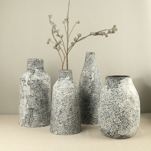 Set of four textured vases on a neutral background