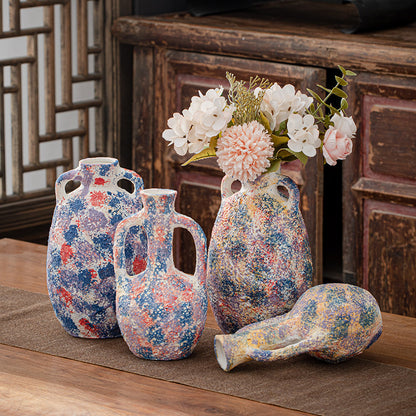 Set of decorative vases with floral patterns on a wooden surface.
