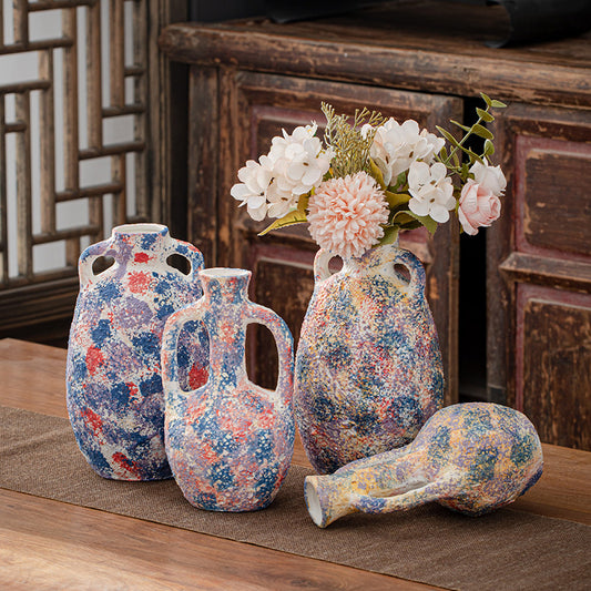 Set of decorative vases with floral patterns on a wooden surface.