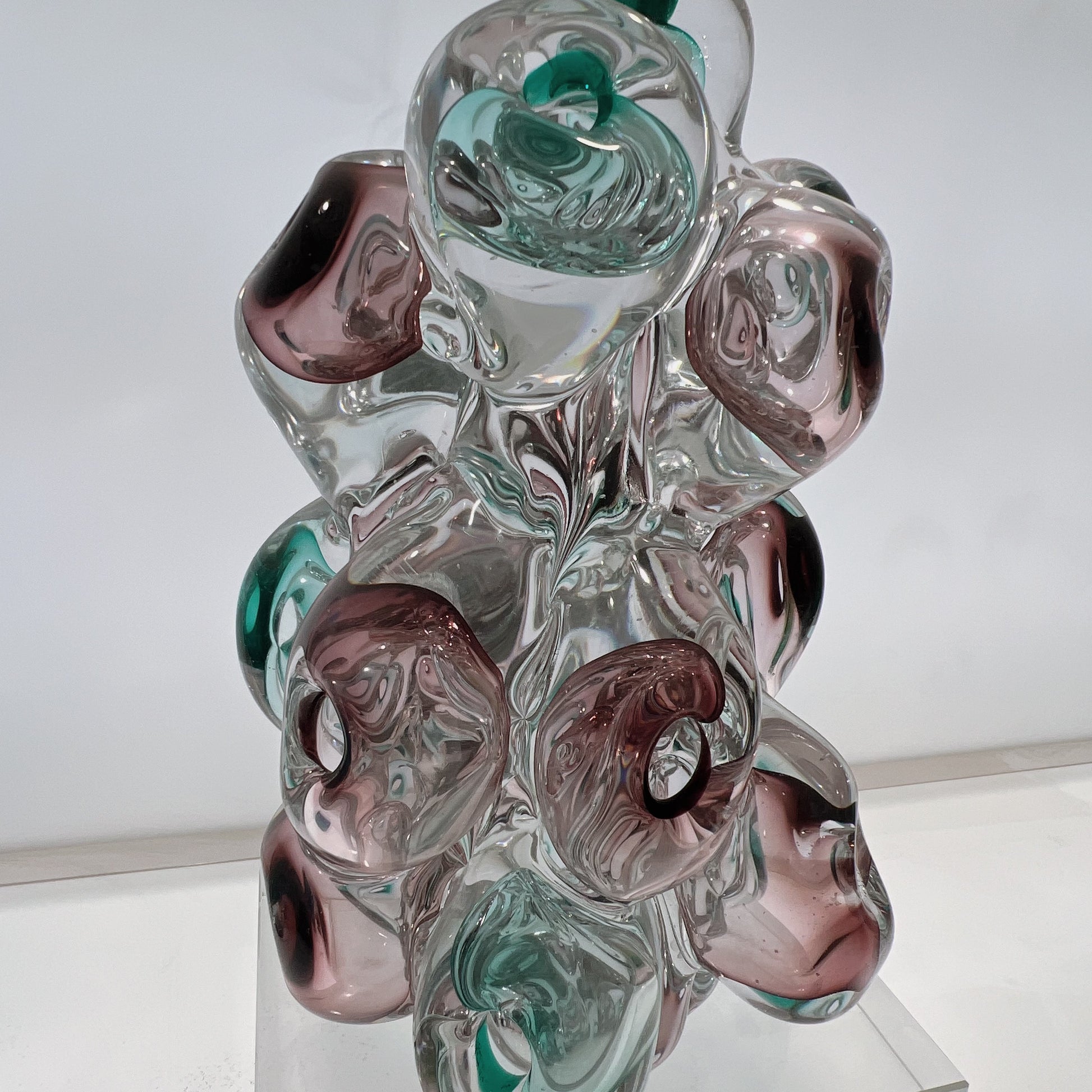 Glass sculpture with multicolored swirls on a white background