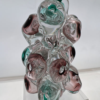 Glass sculpture with multicolored swirls on a white background