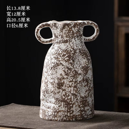 Decorative ceramic vase with handles on a dark surface