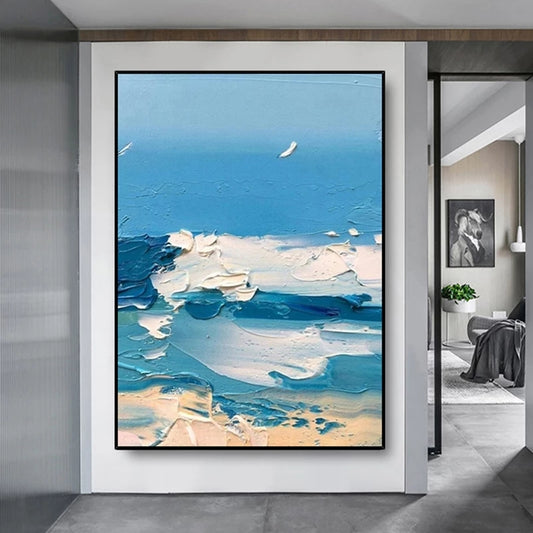 Abstract painting of a beach scene with blue sky and white clouds in a modern interior setting.