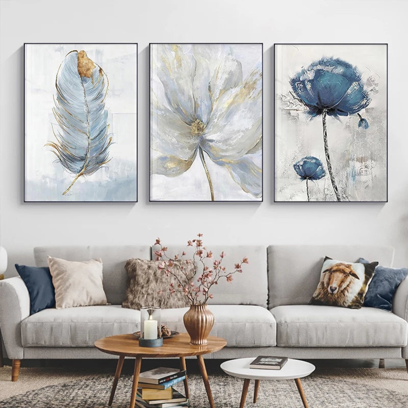 Three abstract floral artworks above a gray sofa in a living room.