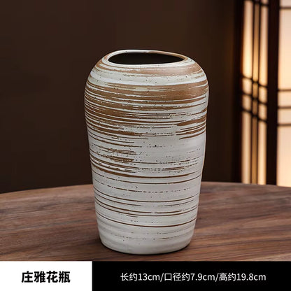 Ceramic vase with striped design on a wooden surface