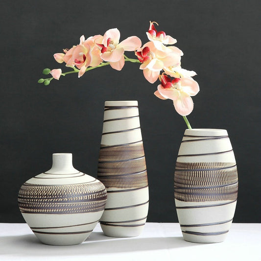 Three decorative vases with striped patterns on a dark background