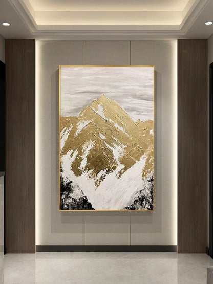 Abstract art piece with gold and white mountain design on a wall.