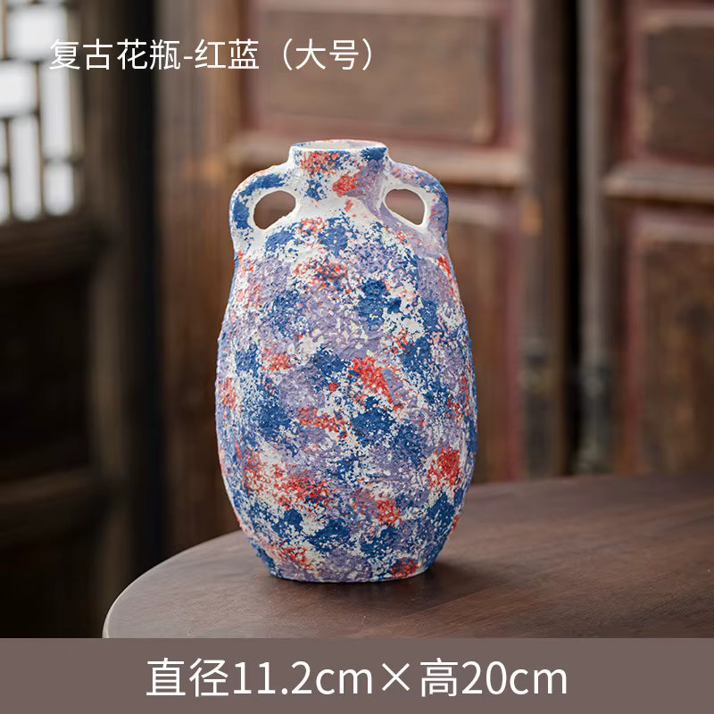 Decorative ceramic vase with blue and red patterns on a wooden surface