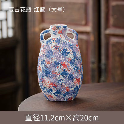 Decorative ceramic vase with blue and red patterns on a wooden surface
