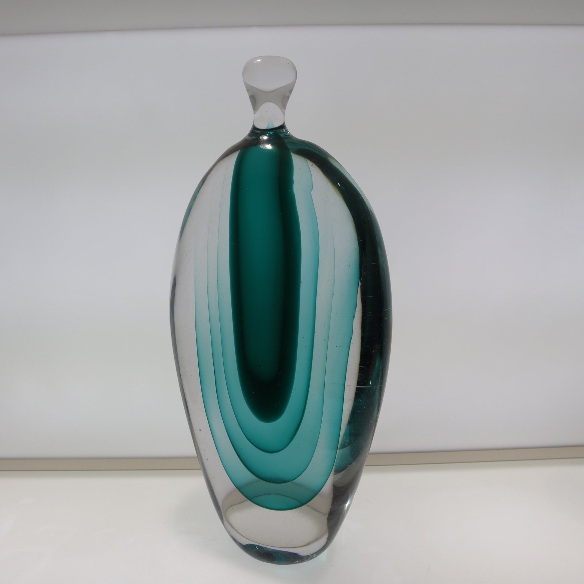 Glass vase with teal and clear design on a white background