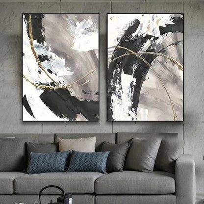 Two abstract art pieces on a wall above a gray sofa with decorative pillows.