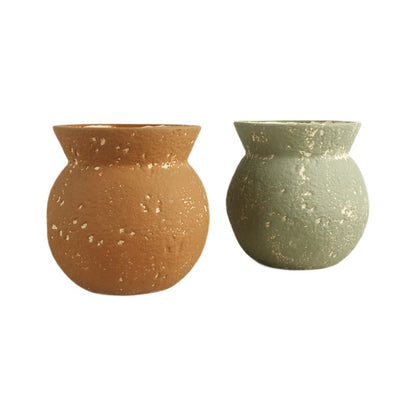 Two terracotta pots, one brown and one green, on a white background