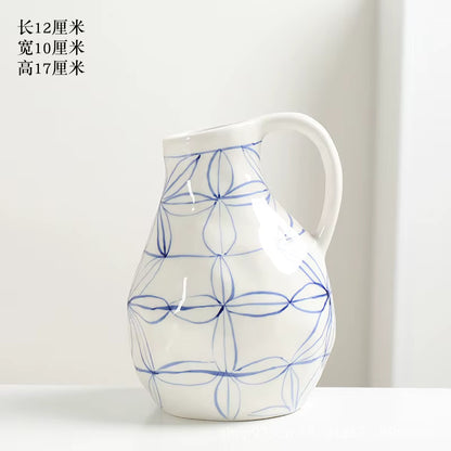White ceramic pitcher with blue floral patterns on a white background