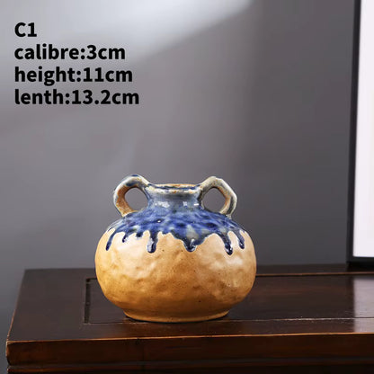 Ceramic vase with blue glaze on a wooden surface against a gray background