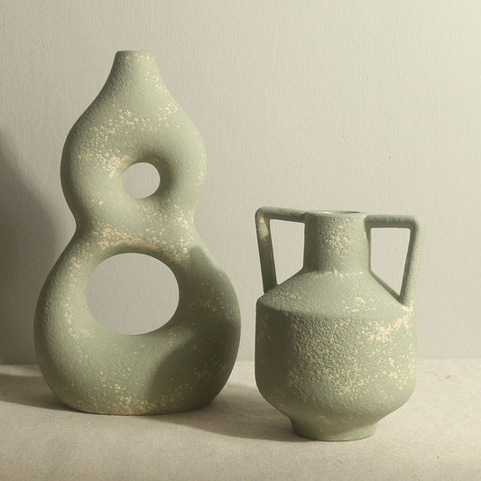 Two green ceramic vases on a neutral background