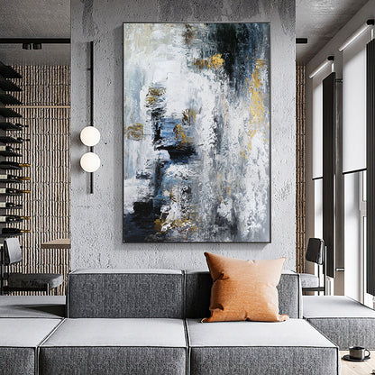Abstract painting in a modern living room with a gray sofa and orange pillow.