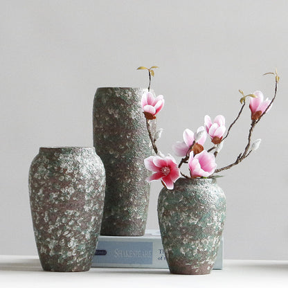 Three decorative vases with floral arrangements on a light gray background