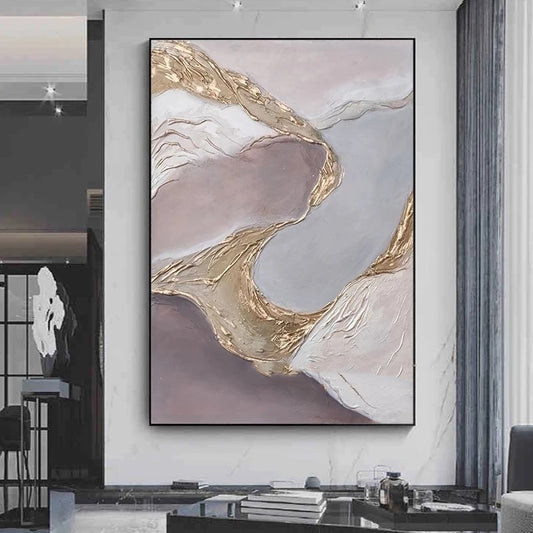 Abstract art piece with gold and pink tones on a wall in a modern interior setting.