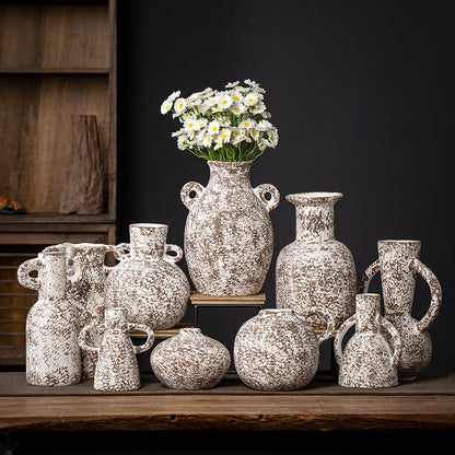 Collection of decorative ceramic vases on a wooden surface with a dark background
