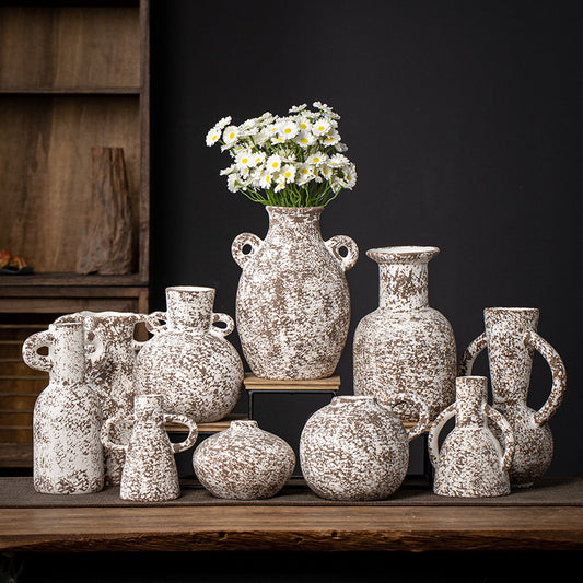Collection of decorative ceramic vases on a wooden surface with a dark background