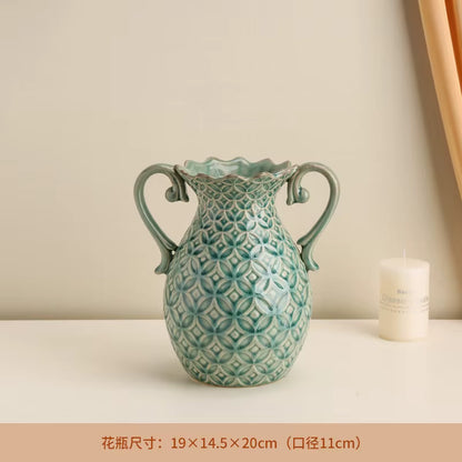 Decorative ceramic vase with geometric pattern on a beige surface with a candle.