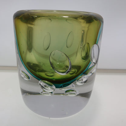 Green glass vase with bubble design on a white background