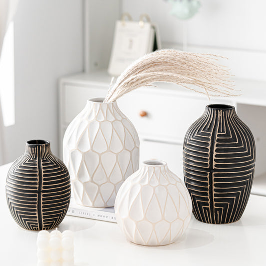 Set of four decorative vases with geometric patterns on a white surface.
