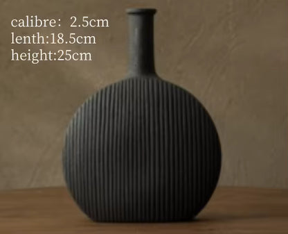 Black ribbed vase on a wooden surface with measurements displayed.