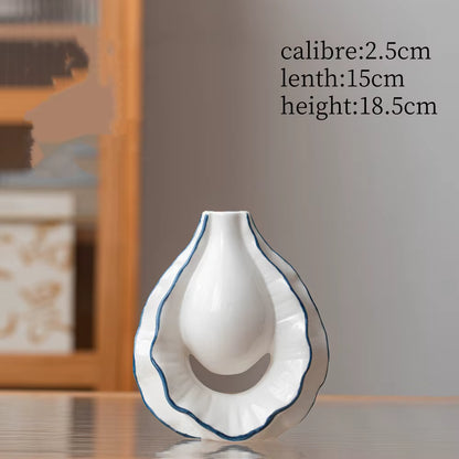 White ceramic vase with blue rim on a wooden surface, measurements displayed.