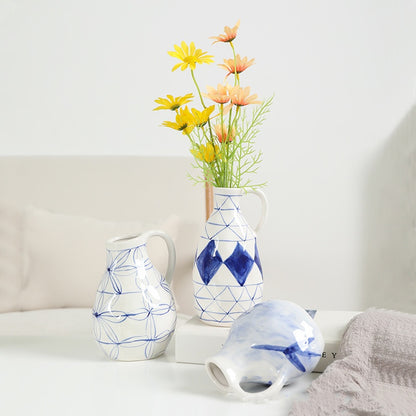 Three ceramic vases with geometric patterns on a white surface.