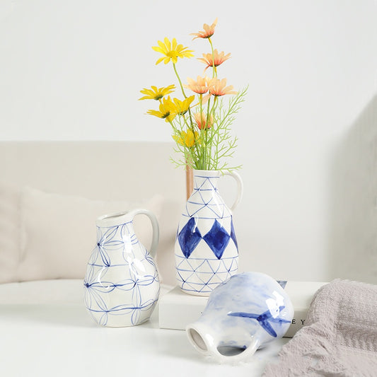 Three ceramic vases with geometric patterns on a white surface.