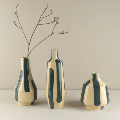 Three ceramic vases with green and beige design on a neutral background