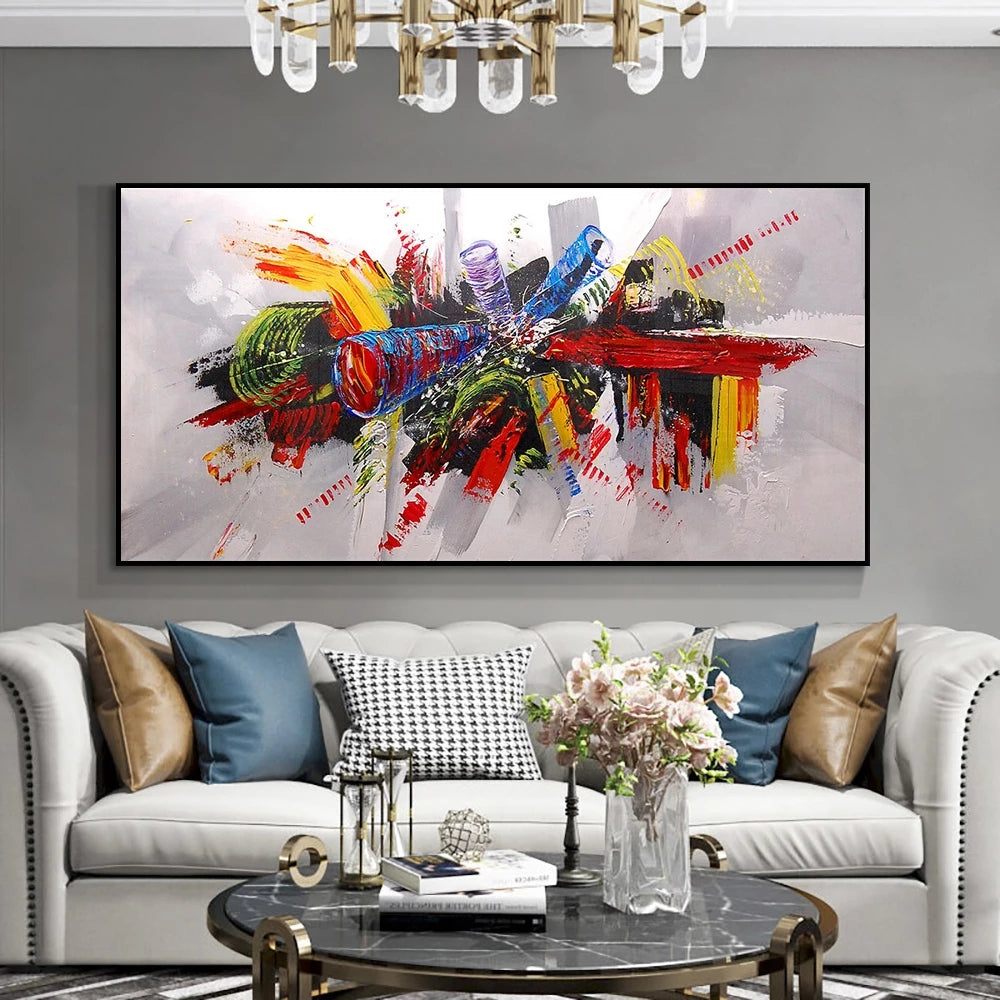 Living room with a colorful abstract painting on the wall, white sofa with decorative pillows, and a coffee table with a vase of flowers.