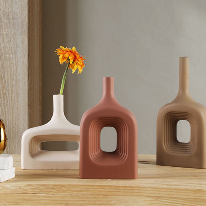 Three ceramic vases with unique designs on a wooden surface.