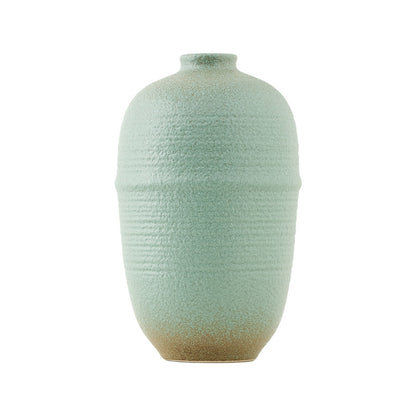 Textured green vase on a white background