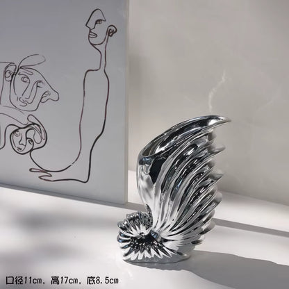 Decorative glass sculpture on a white surface with abstract art in the background