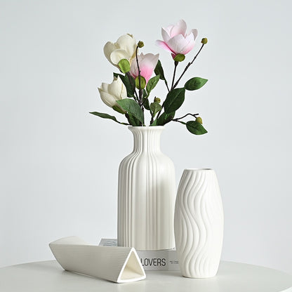 White ceramic vase with floral arrangement on a light gray background