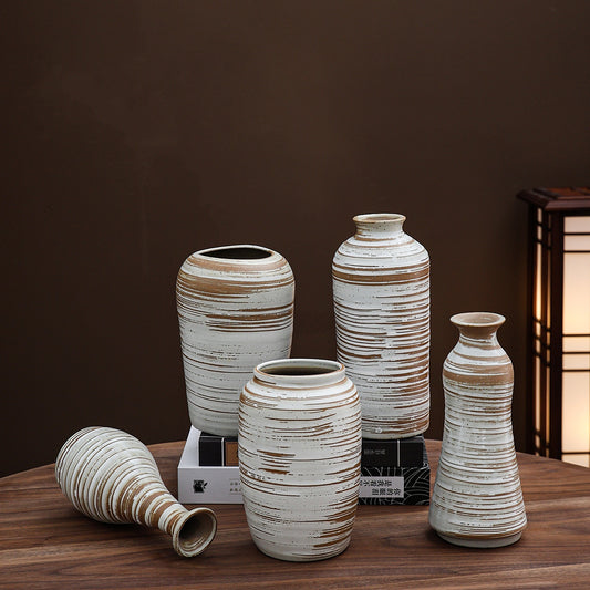 Set of ceramic vases with striped design on a wooden surface against a dark background