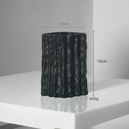 Black textured vase on a white surface with measurements indicated