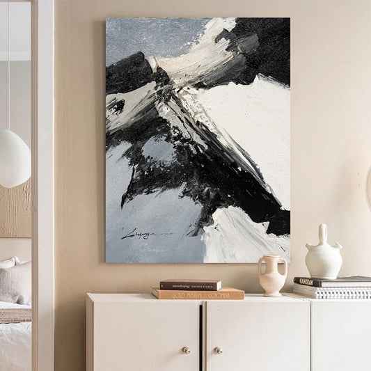 Abstract painting on a wall above a white cabinet with decorative items.