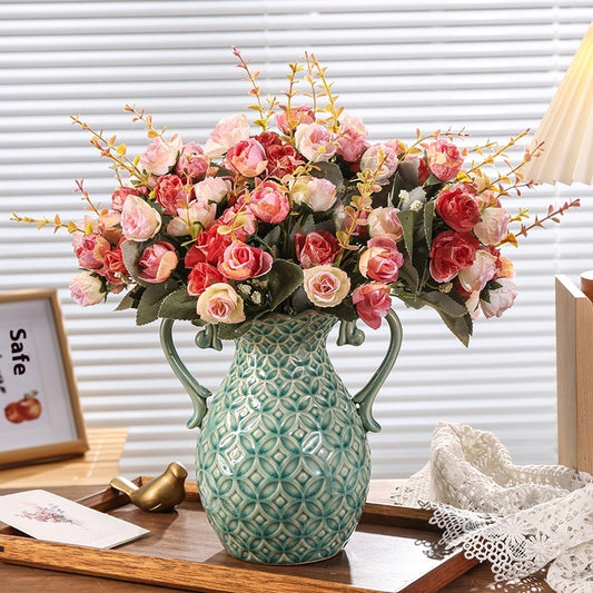 Decorative vase with pink flowers on a wooden surface